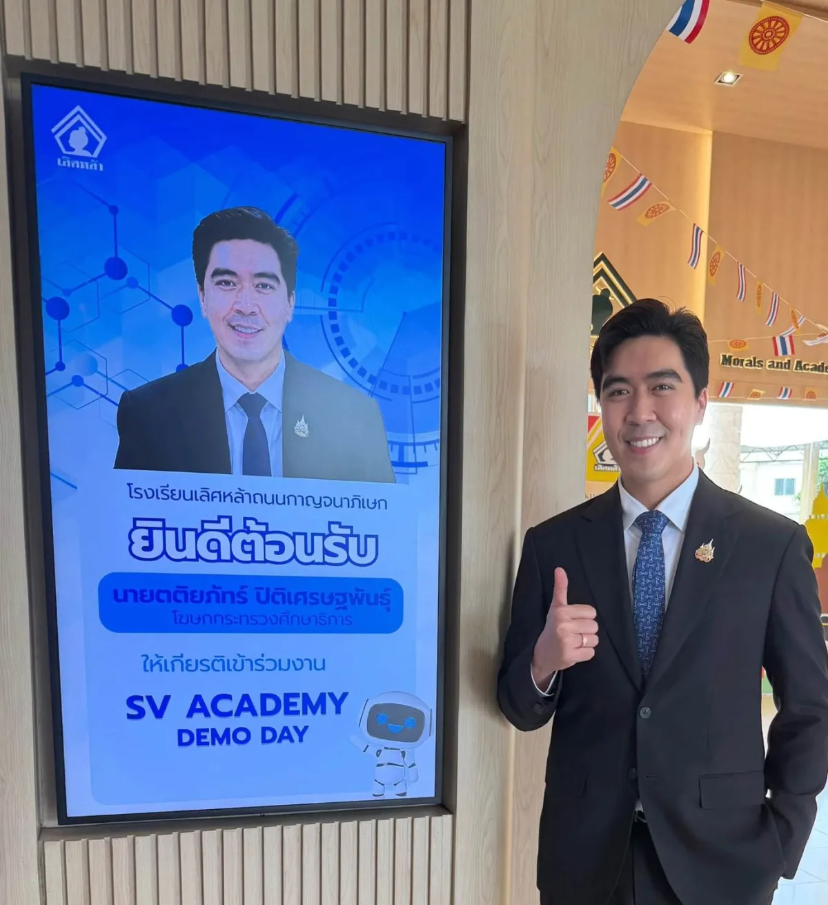 The Ministry of Education spokesperson beside Lertlah School's screen welcoming him to SV Academy Demo Day