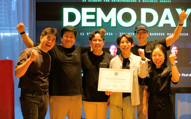 Entrepreneurs cheering with a certificate in front of the Demo Day screen