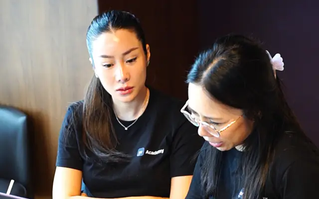 Two business owners working on their app together at a laptop