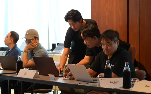 Mentors working alongside business owners at laptops during the workshop