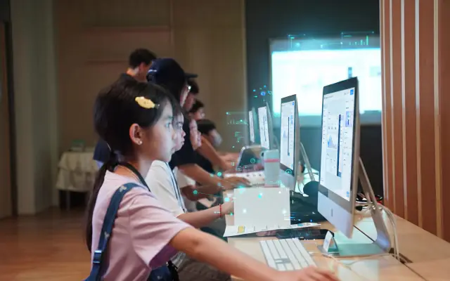 A student coding her app at an iMac