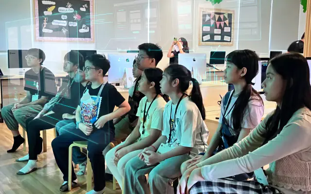 Junior students seated in a row, listening to a talk